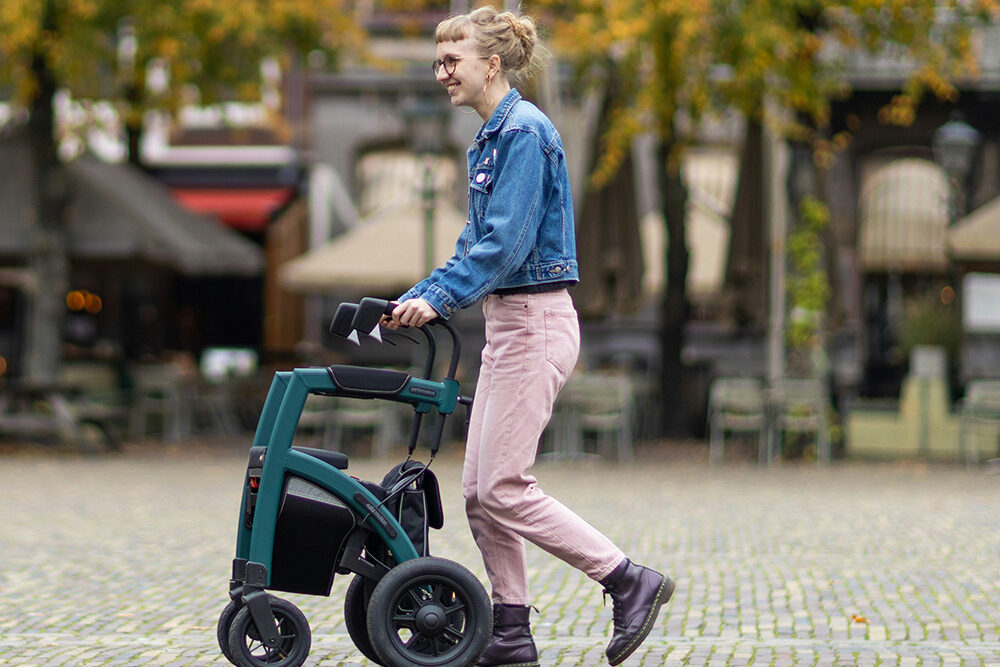 Kvinde går med rollator på vejen